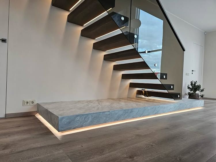 Floating wooden staircase with a glass balustrade and a podium with a grey stone-look surface